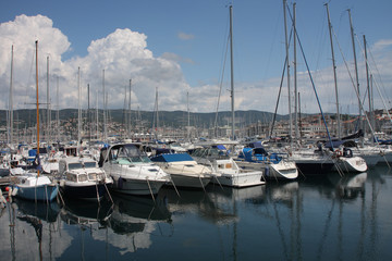 Obraz premium Motor boats and sailboats in harbor in Trieste, Italy