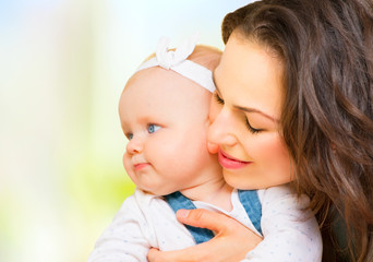 Happy family. Mom and baby girl kissing and hugging at home