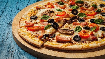 Ham pizza on blue wooden background