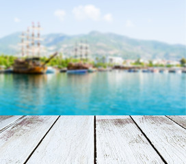 Seascape, ships and mountains blurred, wooden plank in perspective