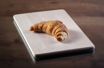 Food. Fresh baked bread on bread board with wooden texture and w