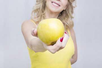 Happy and healthy woman showing an apple 