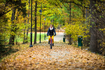 Obraz premium Urban biking - woman riding bike in city park 