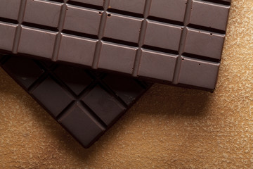 Dark chocolate bar on brown handmade paper background