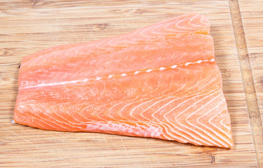 Fresh salmon fillet on a wooden background. Sources of omega 3 fatty acids.