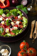 Fresh greek salad with Feta and vegetables on purple plate