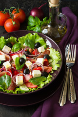 Fresh greek salad with Feta and vegetables on purple plate