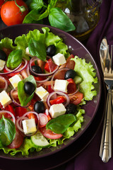 Fresh greek salad with Feta and vegetables on purple plate