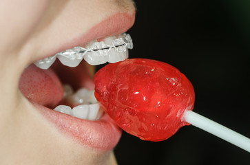 Woman licking sweet sugar candy closeup