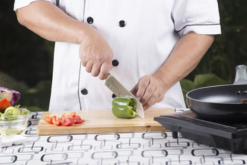 Chef cutting green bell pepper