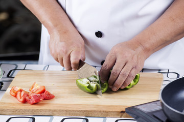 Chef cutting green bell pepper