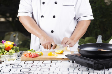 Chef cutting yellow bell pepper