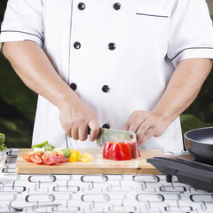 Chef cutting red bell pepper