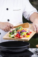 Chef putting vegetable to the pan