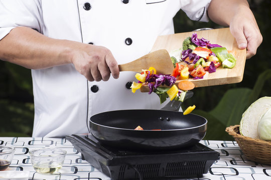 Chef putting vegetable to the pan