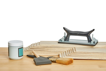 sandpaper holder, stack of veneers and paint brushes