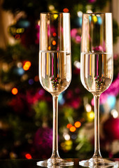 two champagner glasses on glass table with bokeh background