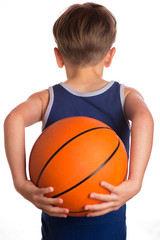 The boy held a basketball ball behind the back.