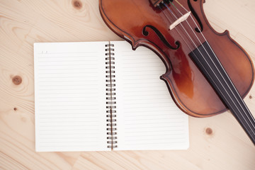 Fototapeta premium Close up of violin and book on pine table