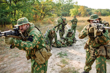 soldiers evacuate the injured fellow  in forest