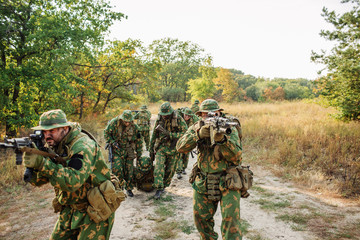 soldiers evacuate the injured fellow  in forest