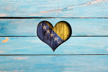 Love Bosnia and Hertzegovina. Heart and flag on a blue wooden board