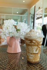 iced frappe coffee in plastic mug put on the rattan weave table