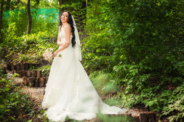 Obraz na płótnie Canvas Bride in wedding dress in forest