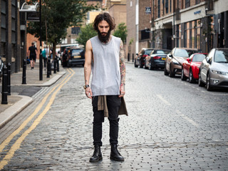 Intense portrait of young tattooed man on the street in Shoreditch, London.