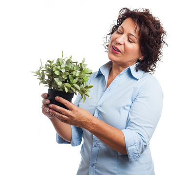 portrait of a mature woman holding a plant on a white background