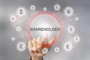 business hand pushing shareholder button - obrazy, fototapety, plakaty