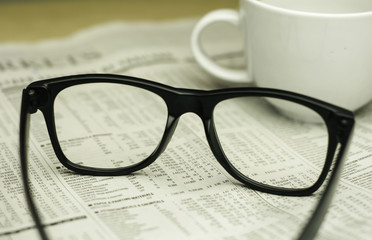 keyboard ,a cup of coffee and a black eyeglasses on a financial