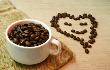 cup of coffee beans with smiling coffee beans on the table