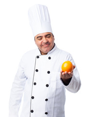 portrait of a cook man holding an orange