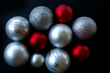 Red and silver Christmas baubles on black background