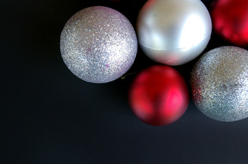 Red and silver Christmas baubles on black background
