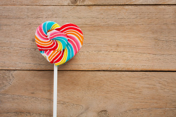 colorful heart lollipop on wood background