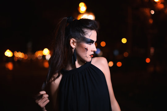 Beautiful woman with Halloween makeup. Close up street night portrait. 