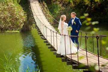 Bride and groom outdoors on bridge