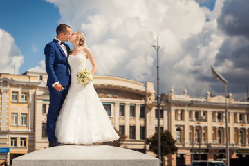 Kissing bride and groom in front of building