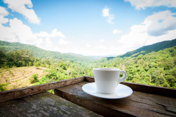 coffee cup on wooden with blurry nature background