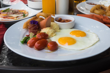 american breakfast with fried eggs, bacon, sausage  and juice