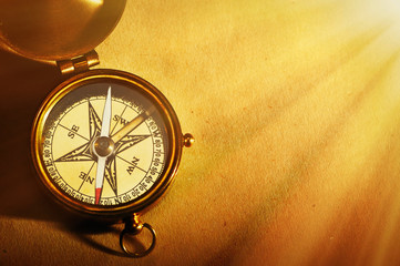 Antique brass compass over old background