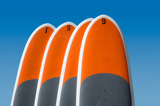 Four stand up paddle boards isolated against blue sky
