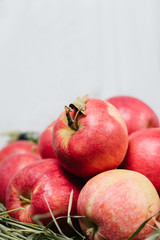 Apples on green grass on a background of white textiles and wooden wall