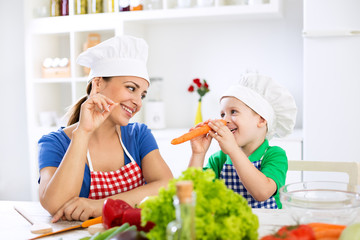 Beautiful attractive mother and child playing with vegetables