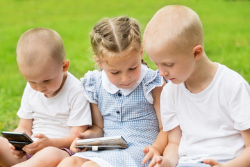 Children using smartphones in park