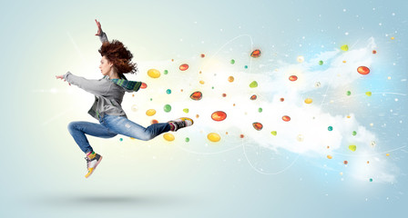 Beautiful woman jumping with colorful gems and crystals on the b