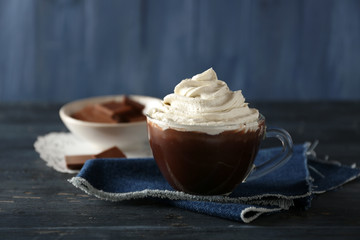 Cup of coffee with cream on color wooden background