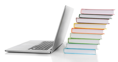 Stack of books with laptop isolated on white